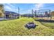 Lush backyard featuring a fire pit, trampoline, and screened-in patio at 3880 Pinstar Ter, North Port, FL 34287