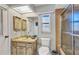Bathroom featuring a shower with tan tile, a toilet, and a vanity with marble-style countertop at 3880 Pinstar Ter, North Port, FL 34287