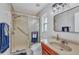 This bathroom has a shower with sliding glass doors, a window, and modern lighting at 3880 Pinstar Ter, North Port, FL 34287