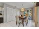 Cozy dining area featuring a wooden table, seating for four, and modern light fixture; tile flooring throughout at 3880 Pinstar Ter, North Port, FL 34287