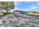 Long concrete driveway with ample parking, leading to a well-kept home with lush greenery in the surrounding yard at 3880 Pinstar Ter, North Port, FL 34287