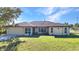 A sunny exterior shot of a single-story home with a two-car garage and well-maintained lawn at 3880 Pinstar Ter, North Port, FL 34287