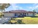 Charming single-story home with a well-maintained lawn, attached garage, and inviting facade under a blue sky at 3880 Pinstar Ter, North Port, FL 34287