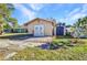 Exterior view of garage with white double doors, lawn, and an outbuilding at 3880 Pinstar Ter, North Port, FL 34287