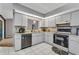 Updated kitchen with white cabinets, stainless steel appliances, tile flooring, and a sink under the window for natural light at 3880 Pinstar Ter, North Port, FL 34287