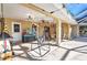This covered patio features a dining area and a hanging chair, ideal for relaxing poolside at 3880 Pinstar Ter, North Port, FL 34287