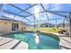 This is a screened-in pool with a blue sky overhead, surrounded by lush landscaping at 3880 Pinstar Ter, North Port, FL 34287