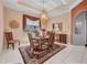 Elegant dining room features a decorative chandelier, ornate ceiling trim, and large windows with a beautiful rug at 412 Panarea Dr, Punta Gorda, FL 33950