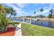 Waterfront property featuring a private dock on a scenic canal with lush landscaping at 412 Panarea Dr, Punta Gorda, FL 33950