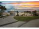 Inviting home at sunset featuring well-manicured lawn, landscaping, and paved driveway at 412 Panarea Dr, Punta Gorda, FL 33950