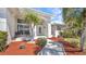 Charming home entrance with a paved walkway surrounded by palm trees and mulch at 412 Panarea Dr, Punta Gorda, FL 33950