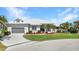 Charming single-story home featuring a manicured lawn, lush landscaping, and attached two-car garage at 412 Panarea Dr, Punta Gorda, FL 33950