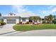 Charming single-story home featuring a manicured lawn, lush landscaping, and attached two-car garage at 412 Panarea Dr, Punta Gorda, FL 33950