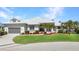 Charming single-story home featuring a manicured lawn, lush landscaping, and attached two-car garage at 412 Panarea Dr, Punta Gorda, FL 33950