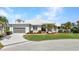 Charming single-story home featuring a manicured lawn, lush landscaping, and attached two-car garage at 412 Panarea Dr, Punta Gorda, FL 33950