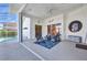 Covered lanai with outdoor seating, sliding glass doors, and a unique porthole window detail at 412 Panarea Dr, Punta Gorda, FL 33950