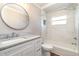 Bathroom featuring vanity with marble countertop, round mirror, and tiled shower/tub at 422 Ravenswood Blvd, Port Charlotte, FL 33954