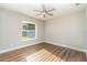 Sunlit bedroom featuring wood-look floors, gray walls, and a ceiling fan at 422 Ravenswood Blvd, Port Charlotte, FL 33954