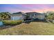 Charming single-story home featuring a manicured lawn, attached garage, and a welcoming walkway to the front door at 422 Ravenswood Blvd, Port Charlotte, FL 33954