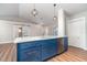 Stylish kitchen island with seating, stainless steel dishwasher and sink, globe pendant lights, and modern cabinetry at 422 Ravenswood Blvd, Port Charlotte, FL 33954