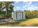 View of the metal backyard shed with a set of stairs and a concrete foundation at 422 Ravenswood Blvd, Port Charlotte, FL 33954