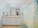 Bright bathroom with double sinks, white cabinetry, and a decorative shower curtain provides a functional and clean space at 4244 Manatee Ln, Punta Gorda, FL 33980
