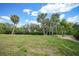 Well-manicured lawn with scattered palm trees creates a serene backyard setting at 5036 San Rocco Ct, Punta Gorda, FL 33950