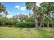 Scenic backyard featuring a canal, lush greenery, and swaying palm trees at 5036 San Rocco Ct, Punta Gorda, FL 33950