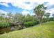 Scenic backyard featuring lush greenery, mature trees, and tranquil canal views at 5036 San Rocco Ct, Punta Gorda, FL 33950