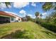 Expansive backyard with a view of mature trees, a canal, and a screened-in patio at 5036 San Rocco Ct, Punta Gorda, FL 33950