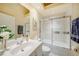 Well-lit bathroom with a bathtub and glass doors and a granite-topped vanity at 5036 San Rocco Ct, Punta Gorda, FL 33950