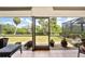 Enjoy the view from this peaceful screened-in patio with tiled floor, seating, and lush landscaping at 5036 San Rocco Ct, Punta Gorda, FL 33950