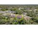 Aerial view of home with screened-in pool surrounded by trees, neighborhoods and roads at 5125 Ariton Rd, North Port, FL 34288