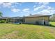 View of the backyard, showcasing the screened pool enclosure and ample green space at 5125 Ariton Rd, North Port, FL 34288
