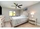 Charming bedroom featuring a ceiling fan, a comfortable bed, and stylish nightstands with lamps, complemented by tile flooring at 5125 Ariton Rd, North Port, FL 34288