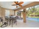 Covered patio with a ceiling fan, dining table, and view of the pool and backyard at 5125 Ariton Rd, North Port, FL 34288