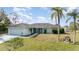 Lovely one-story home with an attached three-car garage, mature palm trees, and a grassy yard at 535 Ramblewood St, Port Charlotte, FL 33953