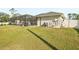 Lovely backyard featuring a screened-in lanai over a swimming pool, utility hardware, and lush green grass at 5805 Casanova Ave, North Port, FL 34291