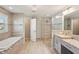 Well-lit bathroom featuring a glass shower, soaking tub, granite counters, and stylish tile work at 5805 Casanova Ave, North Port, FL 34291