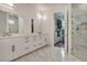 Modern bathroom features double sink vanity, walk-in closet, and glass enclosed shower at 7344 Manthey Ave, North Port, FL 34291