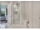 Modern bathroom features glass enclosed shower with marble tile, toilet, and access to a walk-in closet at 7344 Manthey Ave, North Port, FL 34291