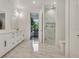 Modern bathroom features double sink vanity, walk-in closet, and glass enclosed shower with marble tile at 7344 Manthey Ave, North Port, FL 34291