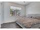 Comfortable bedroom featuring wood floors, a large window, and a comfortable bed with a stylish comforter at 7344 Manthey Ave, North Port, FL 34291