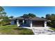 Inviting single-story home with modern garage door, solar panels and lush green lawn at 7344 Manthey Ave, North Port, FL 34291