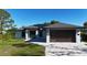 Beautiful home with modern garage door, solar panels and appealing landscaping at 7344 Manthey Ave, North Port, FL 34291