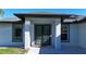 Close-up of the home's modern front entrance with custom door and manicured landscaping at 7344 Manthey Ave, North Port, FL 34291