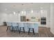 Modern kitchen with stainless steel appliances, sleek white cabinetry and a large center island with seating at 7344 Manthey Ave, North Port, FL 34291