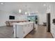Kitchen with stainless steel appliances, sleek white cabinetry and a large center island with a sink at 7344 Manthey Ave, North Port, FL 34291