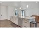 Kitchen island with stainless steel dishwasher, white countertop, and bar stool seating at 7344 Manthey Ave, North Port, FL 34291
