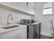 Bright laundry room featuring modern appliances, sleek countertops, and ample storage cabinets at 7344 Manthey Ave, North Port, FL 34291